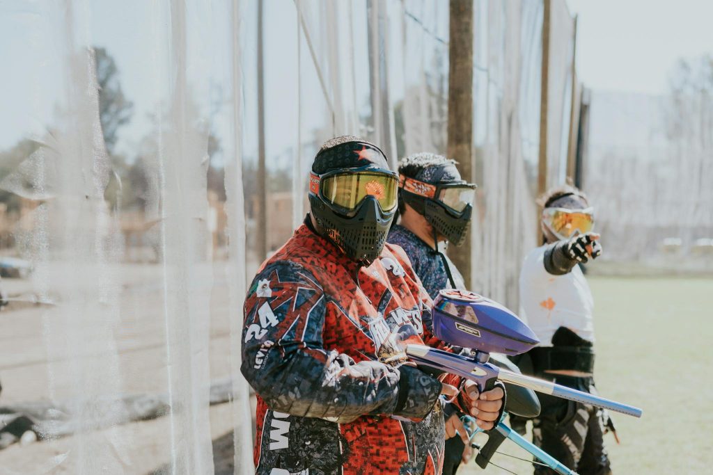 People Standing with Paintball Rifles